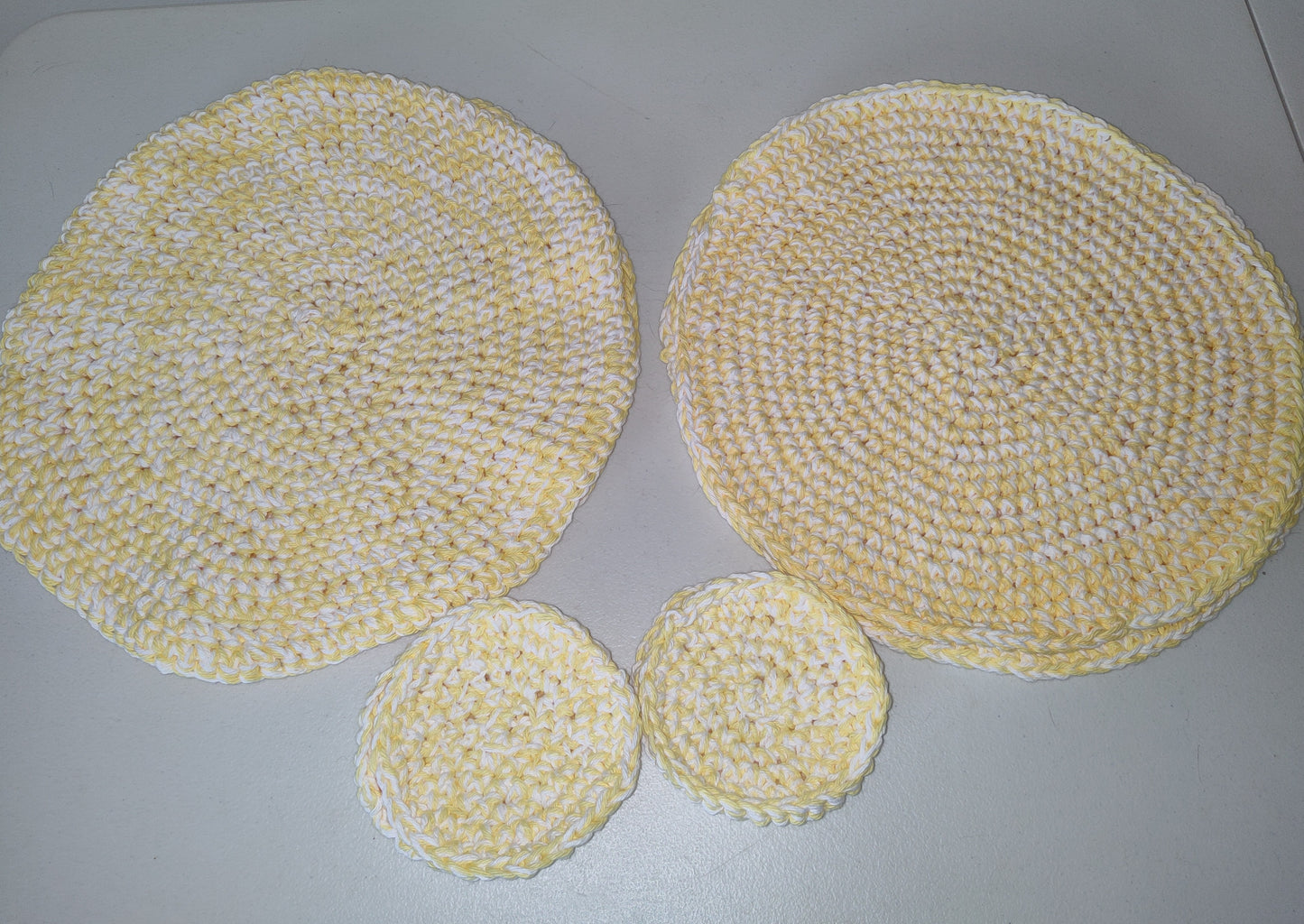 Set of 4 yellow and white table placemats and matching coasters.