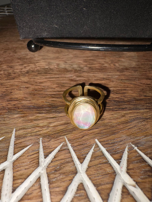 Anillo ajustable dorado con piedra de cristal.