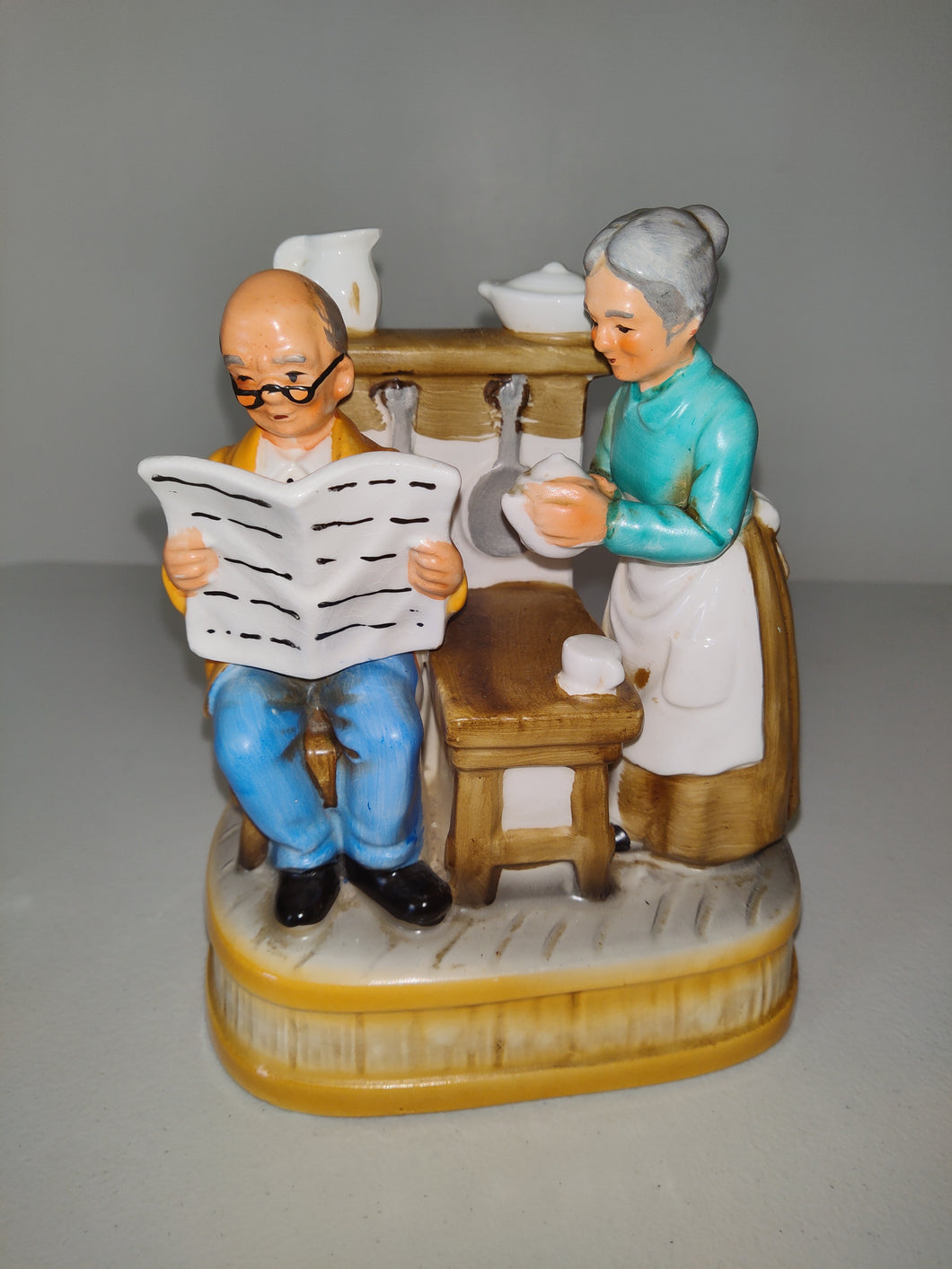 Grandfather and Grandmother Music Box in the Kitchen Reading Newspaper